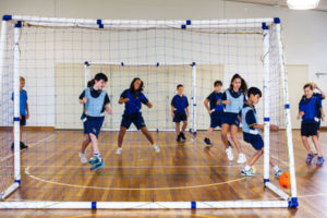 Students playing futsal in school hall