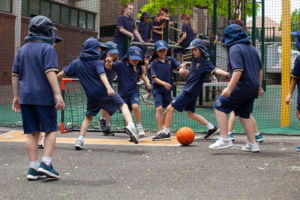 Students playing soccer out in school yard